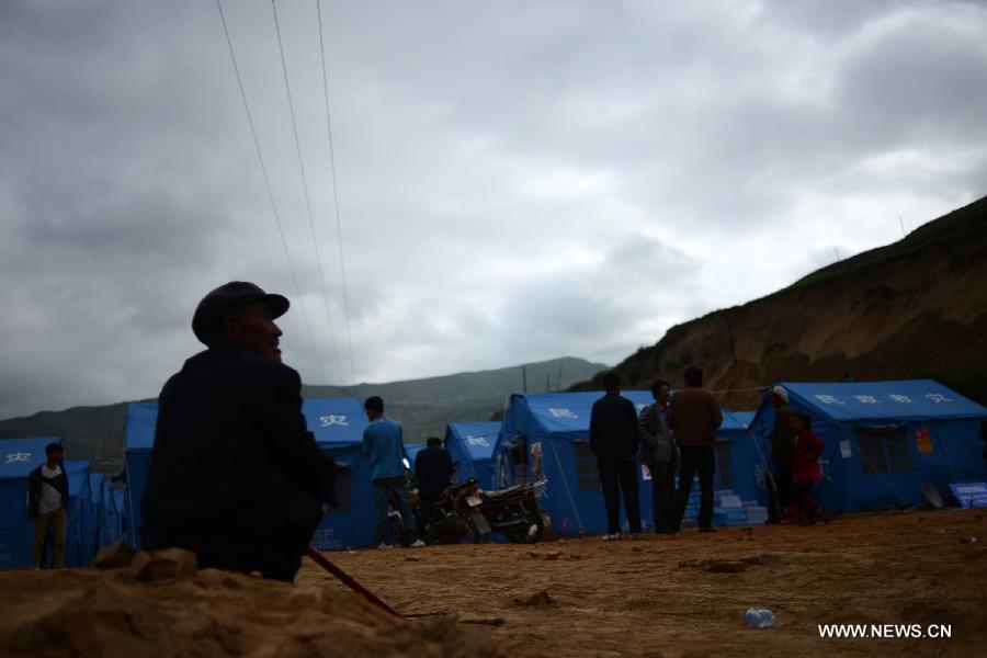 Makeshift tents are set up in the quake-hit Majiagou Village, Meichuan Township, Minxian County, northwest China's Gansu Province, July 24, 2013. Due to a lack of tents, almost ten people could share one in the township. The Ministry of Civil Affairs dispatched more tents and quilts to the quake zone of Gansu on Tuesday evening. A 6.6-magnitude quake jolted the juncture of Minxian and Zhangxian counties in the city of Dingxi at 7:45 a.m. Monday, leaving at least 95 people dead as of Tuesday evening. (Xinhua/Jin Liangkuai)