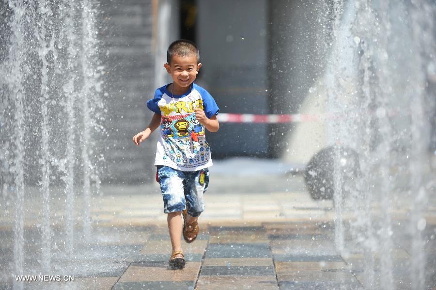 A little boy cools off in a fountain in Beijing, capital of China, July 24, 2013. A heat wave hit Beijing on Wednesday, with the highest temperature reaching 36 degrees Celsius. (Xinhua/Li Xin) 