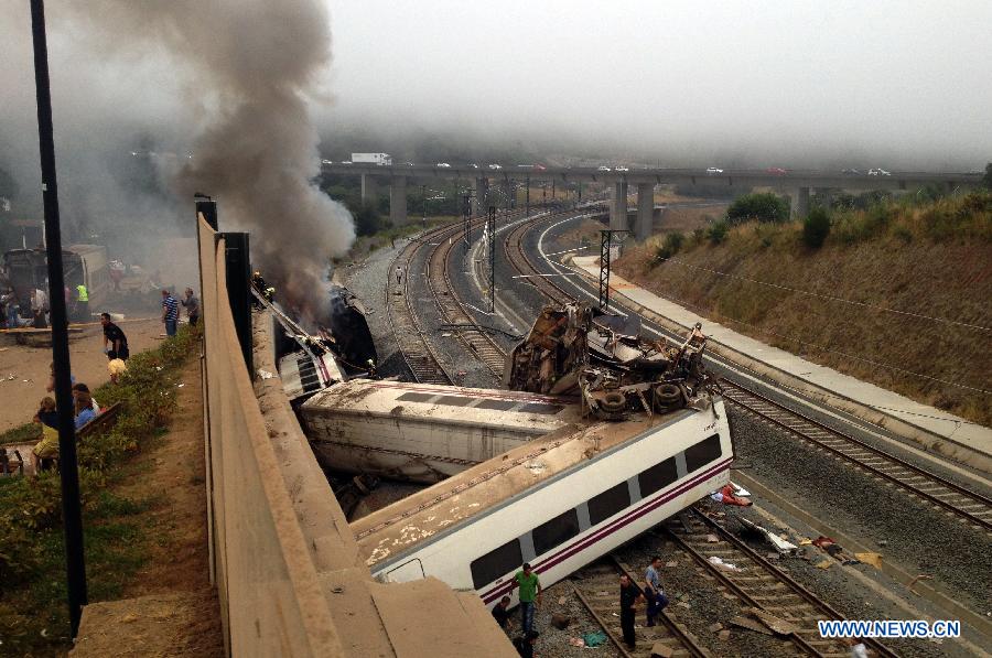 Rescuers work at the site where a train crashed at entrance of Santiago de Compostela Station, autonomous community of Galicia, northwest of Spain, on July 24, 2013. Up to 35 people have died and around 100 injured after a train derailed just outside the city of Santiago de Compostela in the region of Galicia in north-western Spain on Wednesday evening.(Xinhua/La Voz de Galicia)