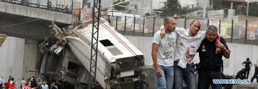 A citizen and a local policeman rescue a survivor at the site where a train crashed at the entrance of the Santiago de Compostela Station, in the autonomous community of Galicia, northwest of Spain, on July 24, 2013. Up to 35 people have died and around 100 injured after a train derailed just outside the city of Santiago de Compostela in the region of Galicia in north-western Spain on Wednesday evening.(Xinhua/La Voz de Galicia)