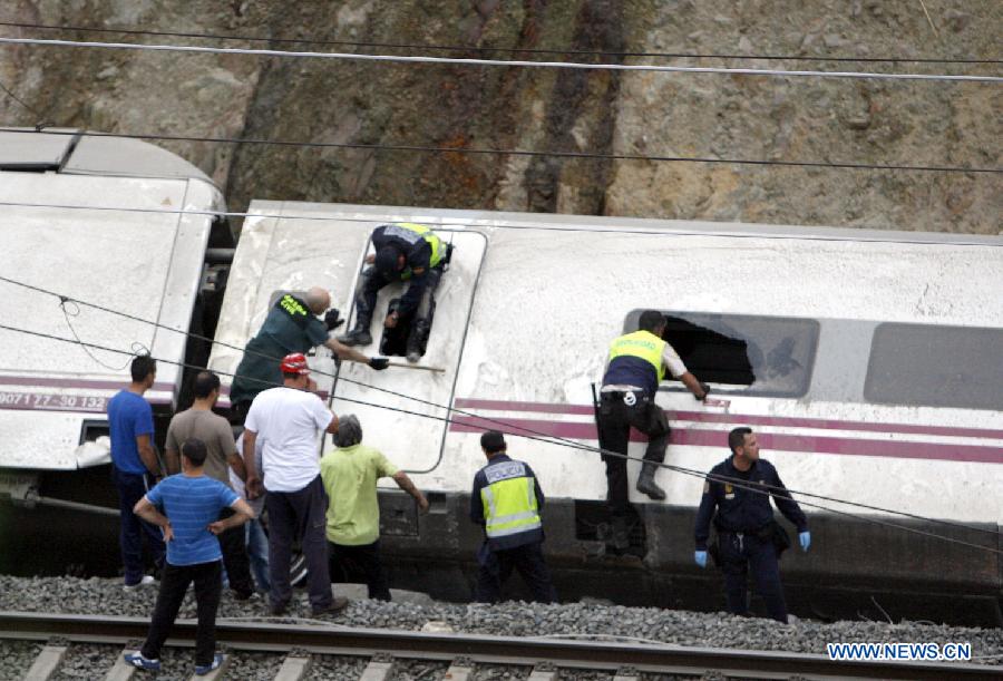 Rescuers and citizens work at the site where a train crashed, at the entrance of Santiago de Compostela Station, in the autonomous community of Galicia, northwest of Spain, on July 24, 2013. Up to 35 people have died and around 100 injured after a train derailed just outside the city of Santiago de Compostela in the region of Galicia in north-western Spain on Wednesday evening. (Xinhua/Oscar Corral)