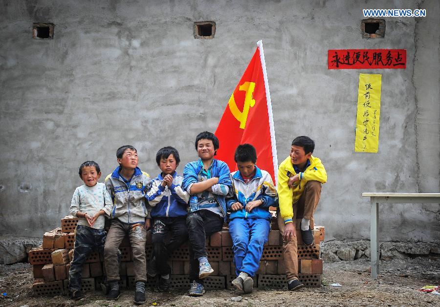Children rest at a service point in Shendu Township of quake-hit Minxian County, northwest China's Gansu Province, July 24, 2013. A 6.6-magnitude quake hit northwest China's Gansu Province on Monday morning, leaving 95 dead and 1,001 injured. (Xinhua/Liu Xiao) 