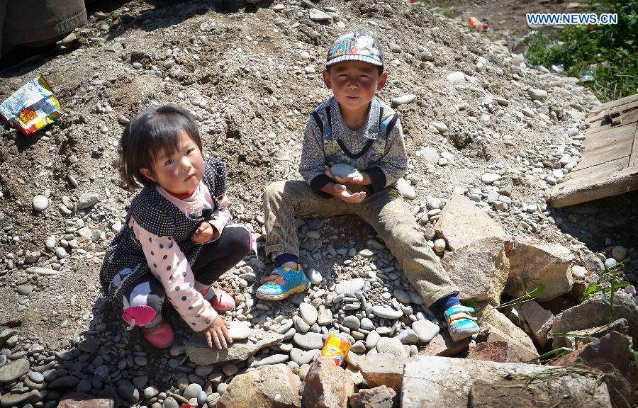 Children play on the ruins in Meichuan Town of quake-hit Minxian County, northwest China's Gansu Province, July 23, 2013. A 6.6-magnitude quake hit northwest China's Gansu Province on Monday morning, leaving 95 dead and 1,001 injured. (Xinhua/Liu Xiao)