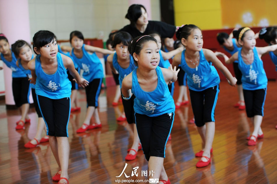 A teacher instructs children practicing dance in the Youth Palace of Yuyao City, east China’s Zhejiang province. The children’s parents are migrant workers. (Photo by Chen Binrong/ vip.people.com.cn)