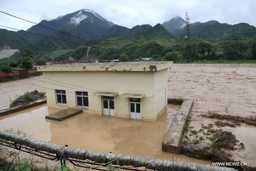 A house is submerged at Huangzhu Town of Chengxian County in Longnan City, northwest China's Gansu Province, July 25, 2013. A torrential rain battered Chengxian County Wednesday night, causing landslips, collapses and traffic disrupted. A total of 1,060 residents have been evacuated by now. (Xinhua/Liu Min) 