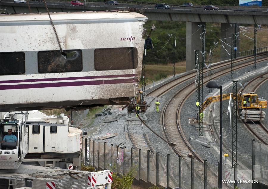 Rescuers work at the accident site at the entrance of Santiago de Compostela Station, in the autonomous community of Galicia, northwest of Spain, on July 25, 2013. The death toll has risen to at least 80 after a train derailed outside the city of Santiago de Compostela on late July 24, according to the police. (Xinhua/Xie Haining)