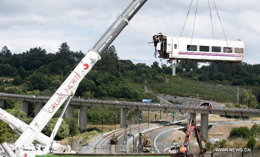 Rescuers work at the accident site at the entrance of Santiago de Compostela Station, in the autonomous community of Galicia, northwest of Spain, on July 25, 2013. The death toll has risen to at least 80 after a train derailed outside the city of Santiago de Compostela on late July 24, according to the police. (Xinhua/Xie Haining)