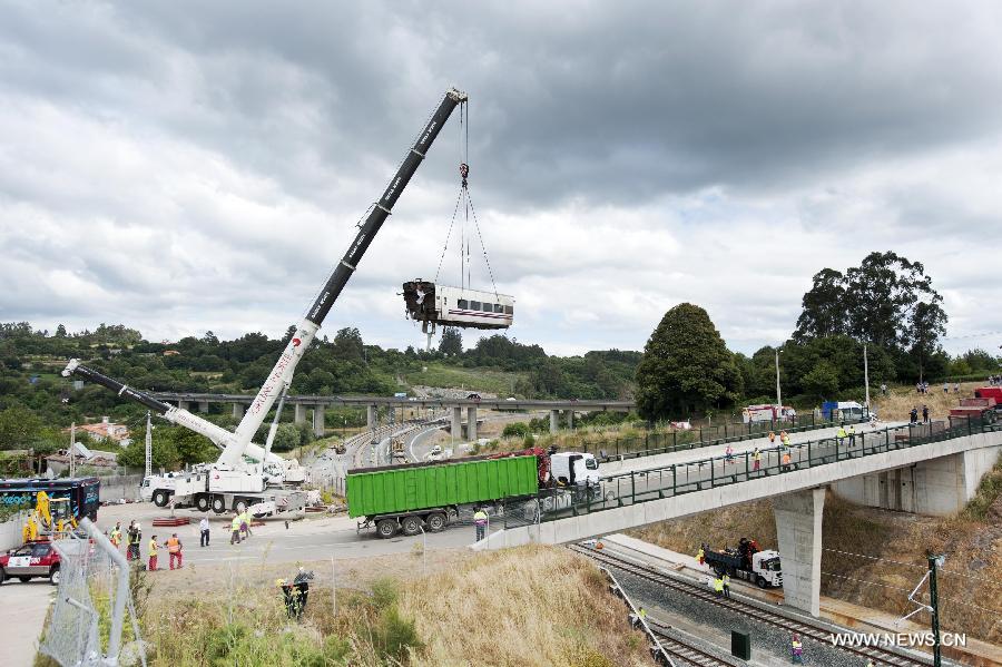 Rescuers work at the accident site at the entrance of Santiago de Compostela Station, in the autonomous community of Galicia, northwest of Spain, on July 25, 2013. The death toll has risen to at least 80 after a train derailed outside the city of Santiago de Compostela on late July 24, according to the police. (Xinhua/Xie Haining)