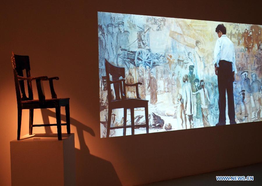 A chair and a painting of late Chinese artist Chen Yifei are displayed in Shanghai Oil Painting and Sculpture Institute, east China's Shanghai, July 25, 2013. An exhibition about the life and the works of Chen Yifei, one of China's most acclaimed painters and visual artists who died in 2005, is opened in the institute on Thursday. (Xinhua/Ren Long)