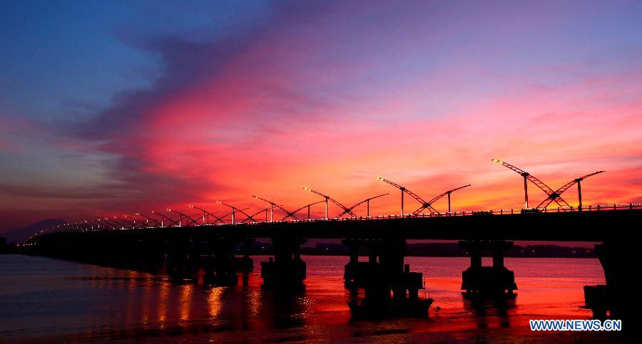 Photo taken on July 25, 2013 shows the Feiyunjiang Bridge under colorful sunset glow after continuous scorching weather in Rui'an City, east China's Zhejiang Province. (Xinhua/Zhuang Yingchang)