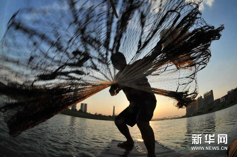 Yi sets his boat in deep water and then throws net. (Photo by Long Hongtao/ Xinhua)