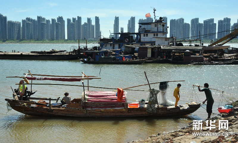 After selling out his fishes, Yi goes back to his home on the boat. (Photo by Long Hongtao/ Xinhua)