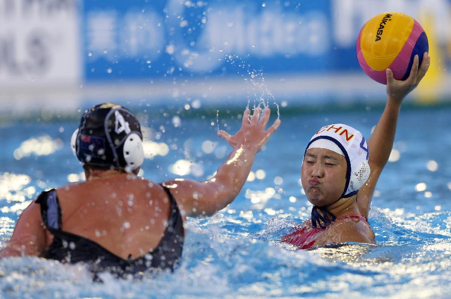 China's Sun Yujun (R) passes the ball during the women's water polo group B preliminary round match between China and New Zealand in the 15th FINA World Championships in Barcelona, Spain, on July 25, 2013. China won 13-5. (Xinhua/Wang Lili)