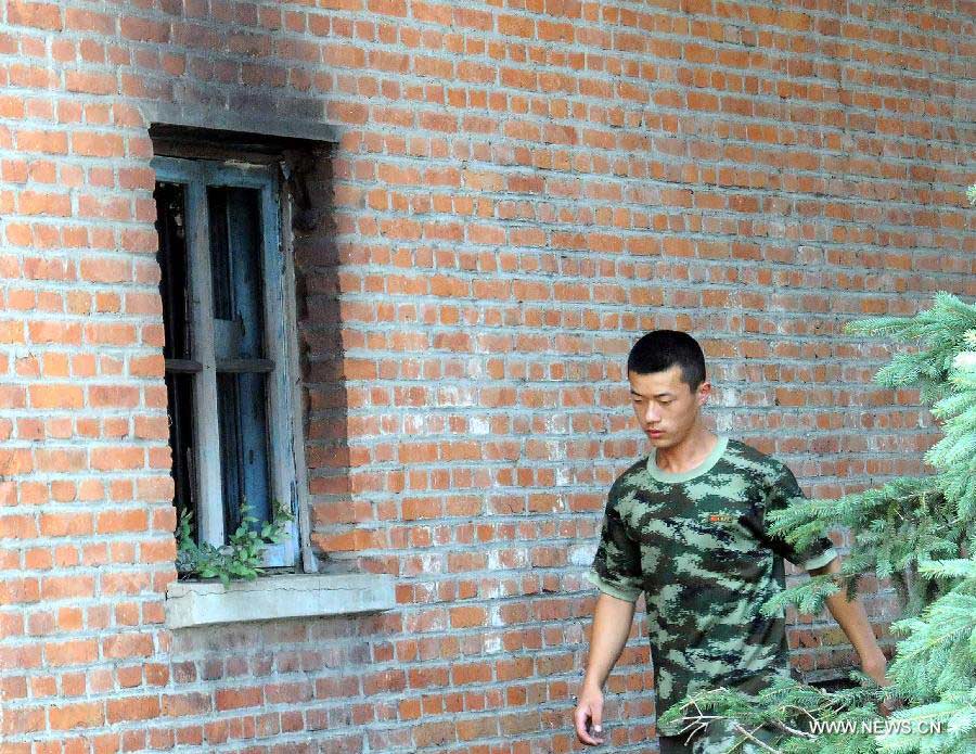 A firefighter walks the accident site at the Lianhe Senior Nursing Home where a fire took place in Hailun City, northeast China's Heilongjiang Province, July 26, 2013. Eleven people were killed in the fire that occurred early Friday. Local police said arson has been confirmed as the cause of the fire. A total of 283 elderly people were living in the nursing home, which was built in October 2005. With an area of 7,000 square meters, it caters for the rural elderly in the city who have no source of income. (Xinhua/Wang Song)