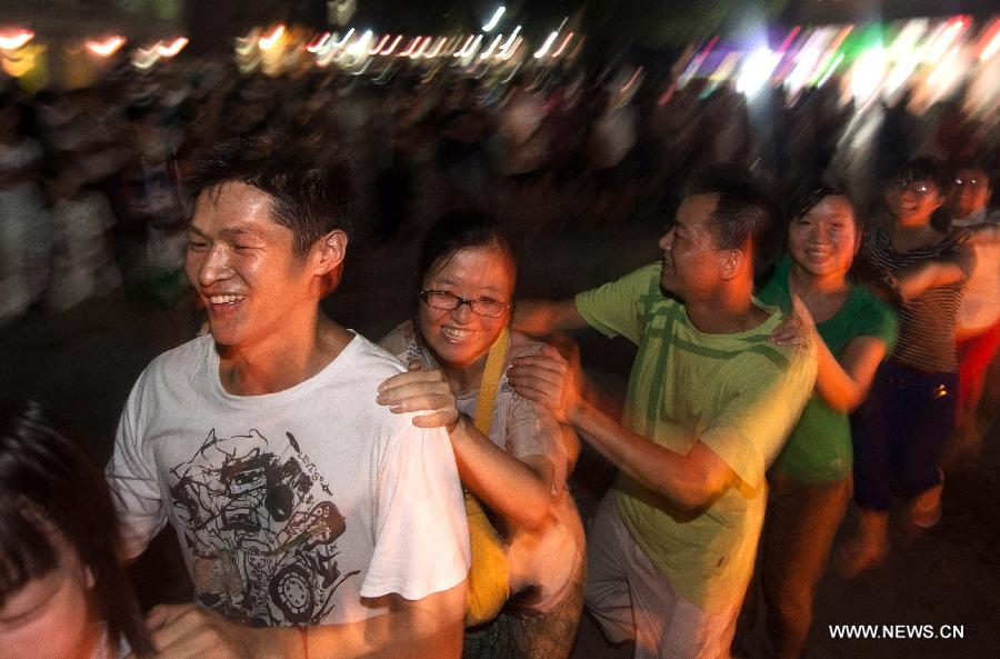 Tourists take part in a campfire party at Guifeng Mountain in Macheng City, central China's Hubei Province, July 27, 2013. A lot of citizens chose to escape the heat in the mountains due to the continuous scorching weather in Hubei province in recent days. (Xinhua/Cheng Min) 