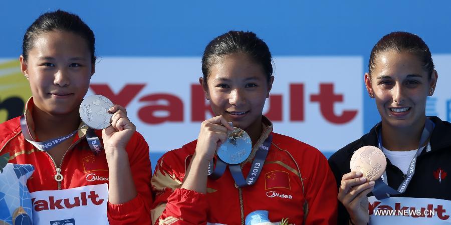 Gold medalist China's He Zi (C), her teammate silver medalist Wang Han and bronze medalist Pamela Ware of Canada pose for pictures during the awarding ceremony for Women's 3m Springboard diving at the 15th FINA World Championships in Barcelona, Spain, on July 27, 2013. He Zi claimed the title with a total score of 383.40 points. (Xinhua/Wang Lili) 