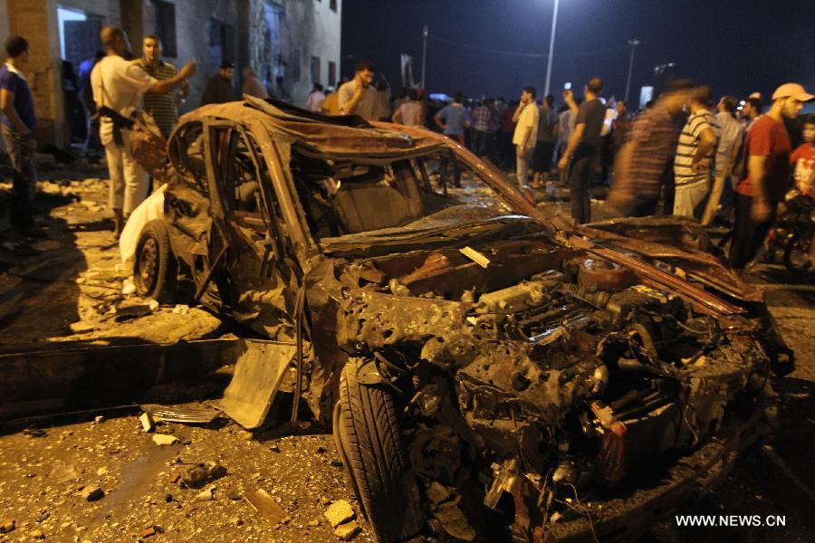 People gather at an explosion site in Benghazi, Libya, July 28, 2013. Two courthouses in Libya's eastern city of Benghazi were hit by explosions on Sunday night, leaving 13 people injured and causing property damage, security sources told Xinhua. (Xinhua)