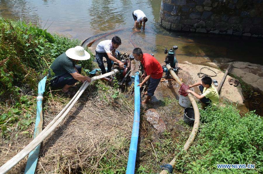 Villagers pump water to irrigate rice in the fields at Chenjiaping Village in Zixing City, central China's Hunan Province, July 28, 2013. A drought that has already lasted several weeks is continuing to linger in Hunan, leaving 533,000 people short of drinking water. (Xinhua/He Maofeng)