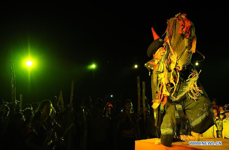 A performer prays on a ceremony to celebrate the Torch Festival at Yunnan Nationalities Village in Kunming City, southwest China's Yunnan Province, July 28, 2013. The Torch Festival, which falls around the 24th day of the sixth Chinese lunar month every year, is the traditional holiday of the Yi ethnic group and some other ethnic groups. (Xinhua/Qin Lang)