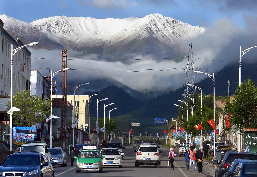 Snow mountains are witnessed in the urban area of Qilian County, northwest China's Qinghai Province, July 28, 2013. The scenic spot attracted many tourists with its snow mountains and blossoming flowers. (Xinhua/Wang Song)