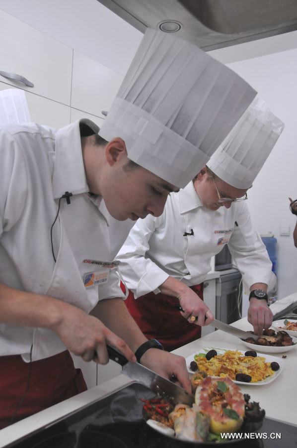 Pierrick Renou and Nick Gollner cut the food for tasting after the cooking competition. "Chopsticks and Beyond" is a Chinese cuisine challenge launched by CRIENGLISH.com to provide a platform for foreign food enthusiasts to show off their Chinese cooking skills and explore creative dishes with exotic flavor. It features China's four great traditions: Sichuan Cuisine, Cantonese Cuisine, Shandong Cuisine and Huaiyang Cuisine. (Xinhuanet/Yang Yi)