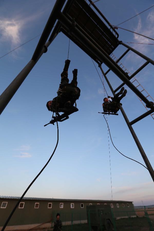 Female soldiers receive rappelling training at the Zhurihe training base in north China's Inner Mongolia Autonomous Region, July 16, 2013. The first female special forces unit established by the Chinese People's Liberation Army received intensive training as the Army Day is coming. The youngest soldier of the unit is 18 years old while the oldest one is 26. All of the female soldiers have college degrees or above and have been trained to master special combat skills. (Xinhua/Wang Jianmin)