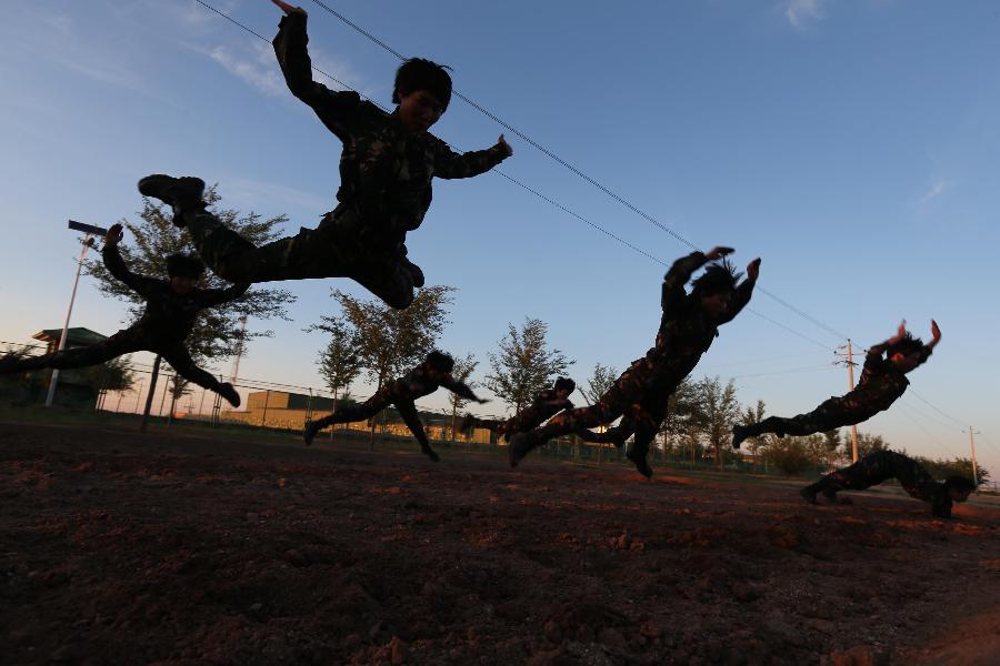 Female soldiers receive training at the Zhurihe training base in north China's Inner Mongolia Autonomous Region, July 16, 2013. The first female special forces unit established by the Chinese People's Liberation Army received intensive training as the Army Day is coming. The youngest soldier of the unit is 18 years old while the oldest one is 26. All of the female soldiers have college degrees or above and have been trained to master special combat skills. (Xinhua/Wang Jianmin)