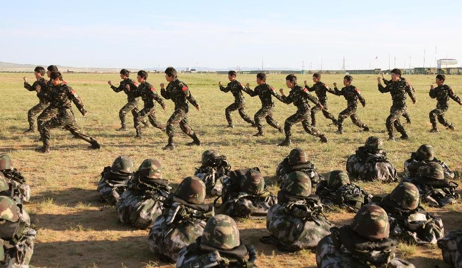 Female soldiers demonstrate military boxing at the Zhurihe training base in north China's Inner Mongolia Autonomous Region, July 16, 2013. The first female special forces unit established by the Chinese People's Liberation Army received intensive training as the Army Day is coming. The youngest soldier of the unit is 18 years old while the oldest one is 26. All of the female soldiers have college degrees or above and have been trained to master special combat skills. (Xinhua/Wang Jianmin)