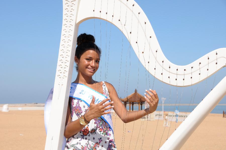 A contestant of the 23rd World Model Organization (WMO) world super model contest finals poses for pictures during a themed photography activity at the Dongjiang shore in north China's Tianjin Municipality, July 28, 2013. In total 37 super models from more than 20 countries and regions all over the world will compete during the final of the 23rd WMO super model contest on Aug. 2, 2013 in Tianjin. (Xinhua/Xue Liqiang) 