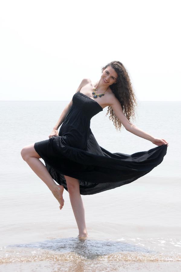 A contestant of the 23rd World Model Organization (WMO) world super model contest finals poses for pictures during a themed photography activity at the Dongjiang shore in north China's Tianjin Municipality, July 28, 2013. In total 37 super models from more than 20 countries and regions all over the world will compete during the final of the 23rd WMO super model contest on Aug. 2, 2013 in Tianjin. (Xinhua/Xue Liqiang) 