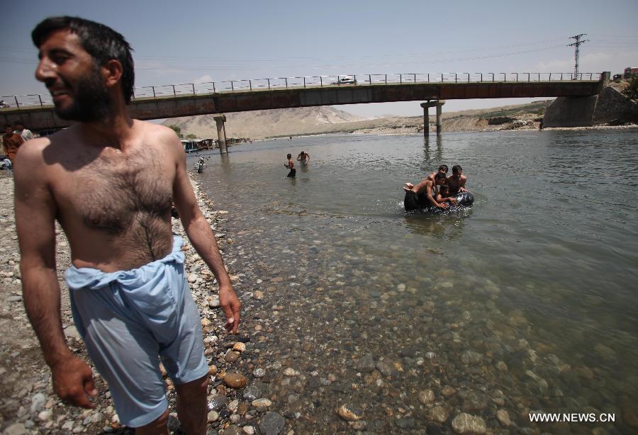 Afghans cool themselves in a canal in Parwan province of Afghanistan on July 29, 2013. (Xinhua/Ahmad Massoud)