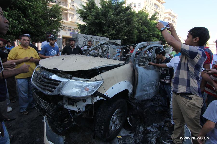 People gather at a site of blast in Libya's eastern city of Benghazi, July 29, 2013. A blast hit Benghazi on Monday, a day after two explosion took place in the city, leaving one injured and a Libyan army vehicle destroyed. (Xinhua)