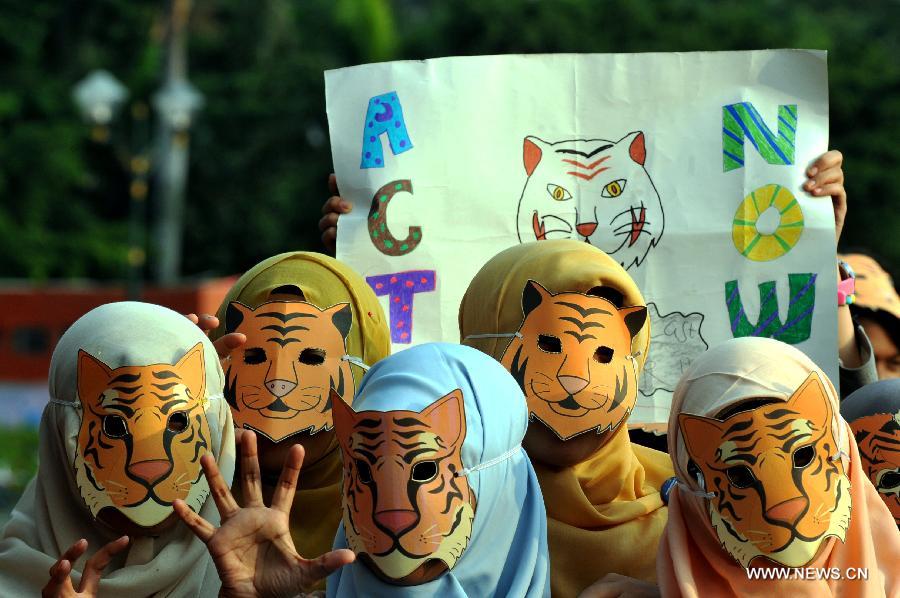 Volunteers attend an activity marking the Global Tiger Day 2013 in Jakarta, Indonesia, July 29, 2013. The Global Tiger Day aims to promote the protection of the habitat of Sumatran tigers and increase awareness of tiger conservation in Indonesia. (Xinhua/Agung Kuncahya B.)