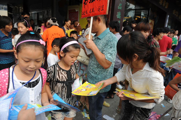 Training institute staff members deliver ads for post-school courses to students in Fuyang, Anhui province. Hei Bai / for China Daily