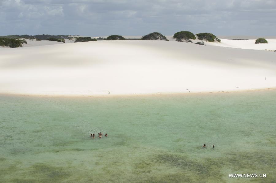 People visit Lencois Maranhenses National Park located in northeast Brazil's Maranhao state, July 28, 2013. At the end of rain season every year, crystal clear lagoons form in the desert here.(Xinhua/Weng Xinyang)