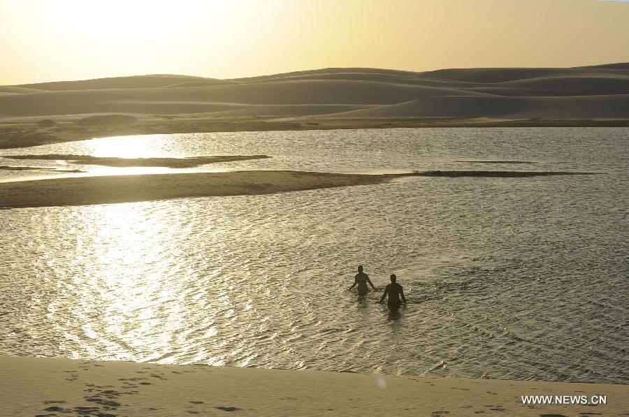 People visit Lencois Maranhenses National Park located in northeast Brazil's Maranhao state, July 28, 2013. At the end of rain season every year, crystal clear lagoons form in the desert here.(Xinhua/Weng Xinyang)