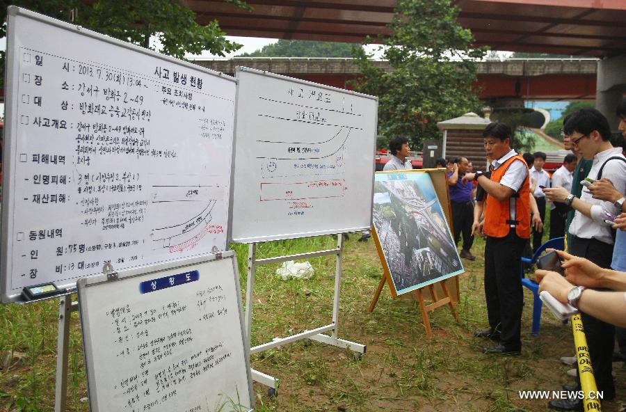 Rescuers introduce the information of the collapse accident to media near the Banghwa Bridge in Seoul, South Korea, on July 30, 2013. Two Chinese workers were killed as a section of an under-construction ramp onto Banghwa Bridge collapsed Tuesday, according to Yonhap. (Xinhua/Yao Qilin)