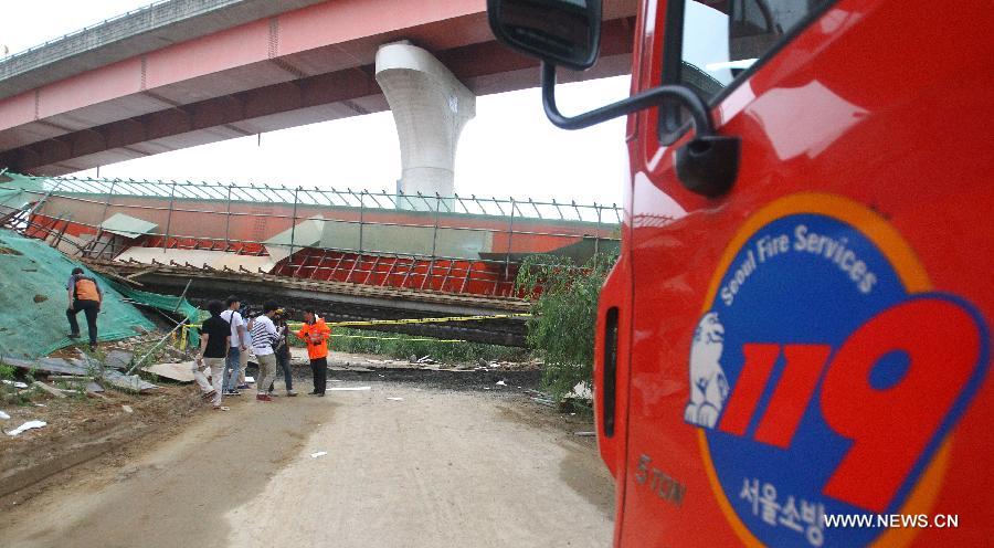 Rescuers work at the collapse site near the Banghwa Bridge in Seoul, South Korea, on July 30, 2013. Two Chinese workers were killed as a section of an under-construction ramp onto Banghwa Bridge collapsed Tuesday, according to Yonhap. (Xinhua/Yao Qilin) 