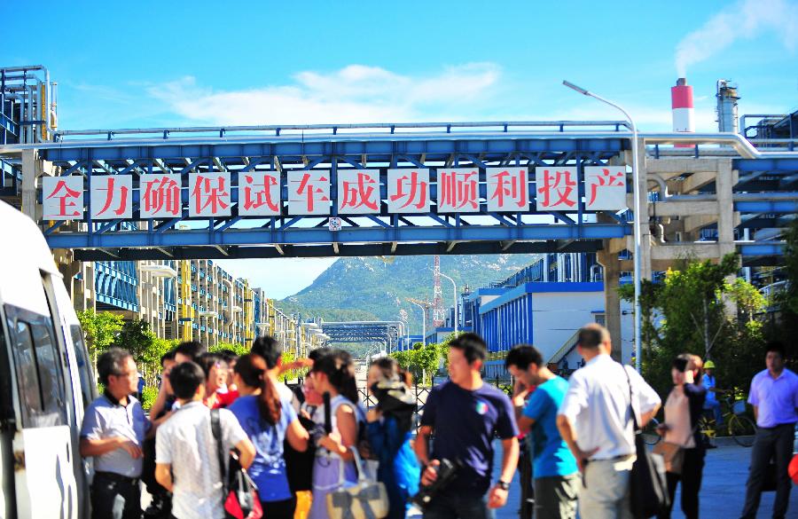 Reporters prepare to enter the accident site at a paraxylene (PX) plant on Gulei Peninsula in Zhangzhou, southeast China's Fujian Province, July 30, 2013. A flash fire followed by an explosion erupted at the plant at 4:35 a.m.. The fire has been brought under control and no casualties have been reported. An initial investigation found that a cracked hydrogen pipeline triggered the fire during a pressure test. (Xinhua/Wei Peiquan)