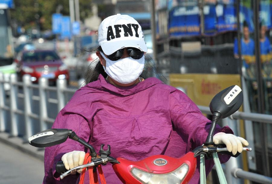 A citizen rides an electromobile in the burning sun in Changsha, capital of central China's Hunan Province, July 30, 2013. High temperatures sustained in the past month in Changsha and will continue in the coming 4 days. (Xinhua/Long Hongtao)