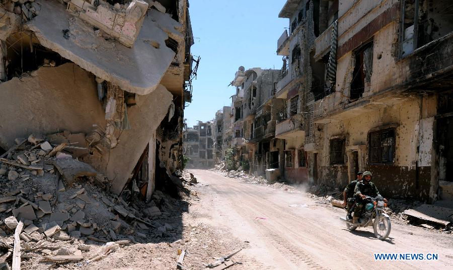 Soldiers of the Syrian army patrol in the street of al-Khalidieh district in central Homs province, Syria, July 30, 2013. The Syrian army announced Monday that its troops successfully regained full control over the strategic al-Khalidieh district in central Homs province after a series of precise operations there, according to the state-TV. (Xinhua/Zhang Naijie)