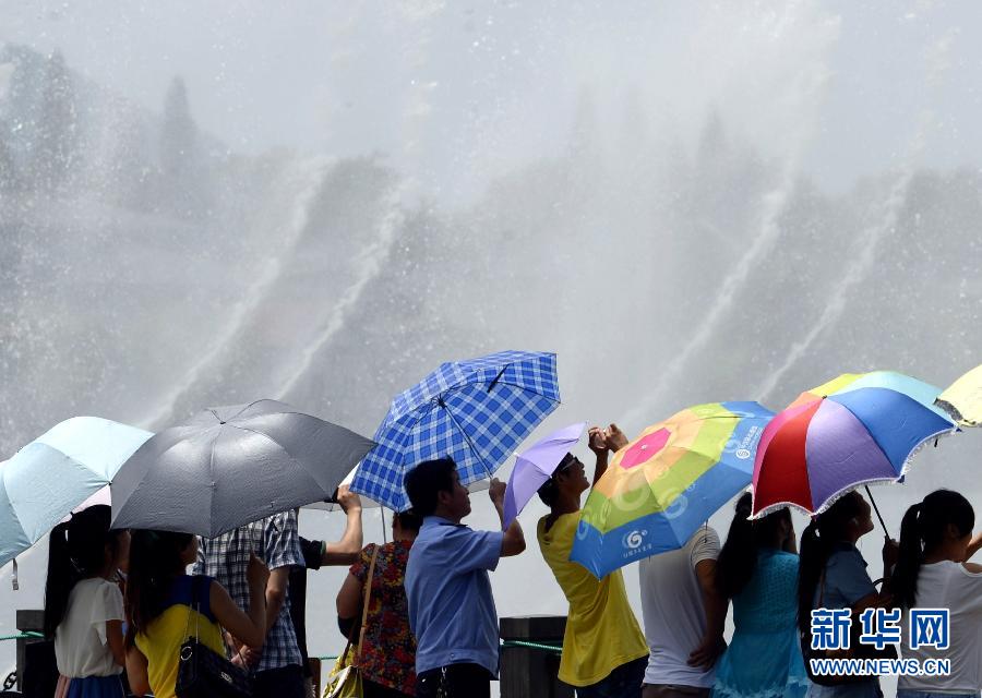 People enjoy music fountain in Hubin Park in Hangzhou on July 28, 2013. Temperatures in many regions in Zhejiang had exceeded 40 degrees Celsius for many days since July, with average precipitation reduced 70 percent. (Xinhua/Shi Jianxue)