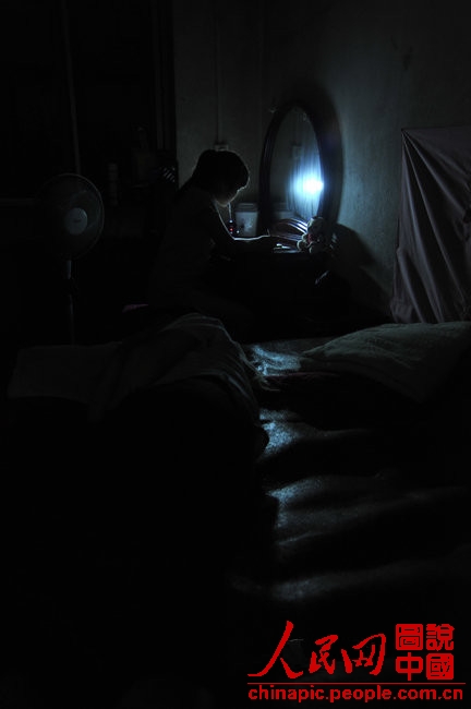 Gao does homework at night on July 12, 2013. Gao must finish all the house work including the massage for her mother and grandmother before doing the homework. When she finished the homework, it was almost midnight. (Xinhua/Hu Linyun)