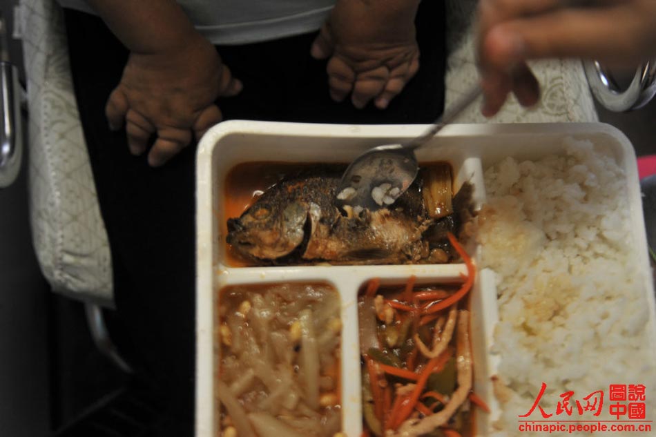 Gao feeds her mother by carefully removing the fish bones on July 12, 2013. Gao's mother's hands and feet have been severely deformed due to postpartum rheumatoid. (Xinhua/HU Linyun)