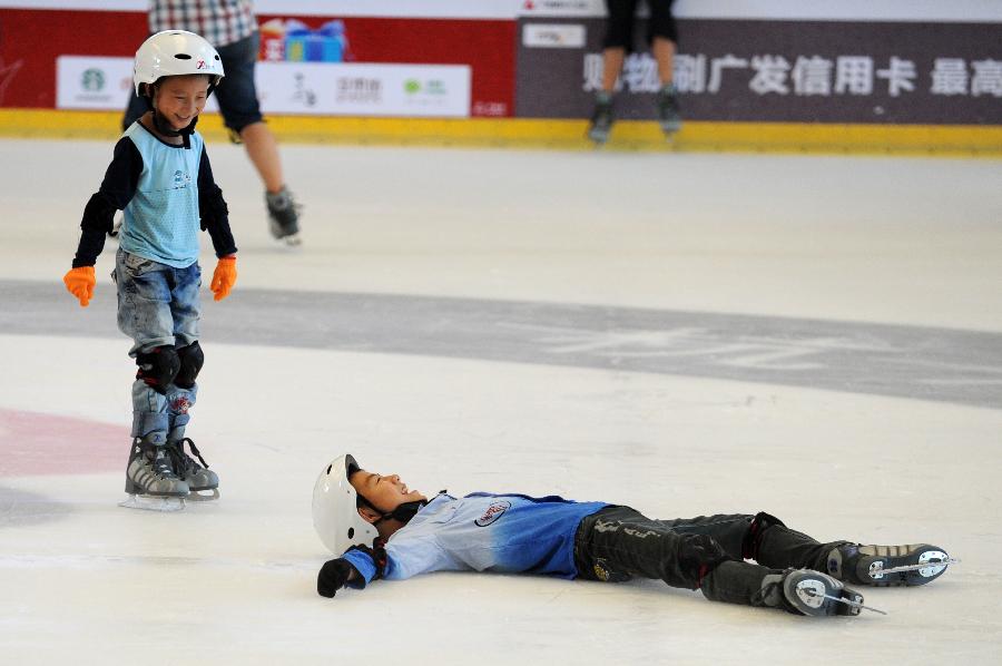 Children enjoy ice skating to relieve the summer heat within a shopping mall in Hangzhou, capital of east China's Zhejiang Province, July 31, 2013. Hangzhou has experienced six days of temperature over 40 degrees Celsius since July 24. Indoor activities like ice skating and swimming has been popular among local citizens to relieve the intense heat. (Xinhua/Ju Huanzong)