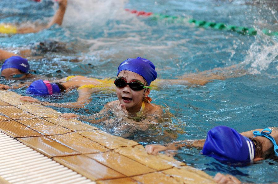 Children learn swimming at an indoor pool in Hangzhou, capital of east China's Zhejiang Province, July 31, 2013. Hangzhou has experienced six days of temperature over 40 degrees Celsius since July 24. Indoor activities like ice skating and swimming has been popular among local citizens to relieve the intense heat. (Xinhua/Ju Huanzong)