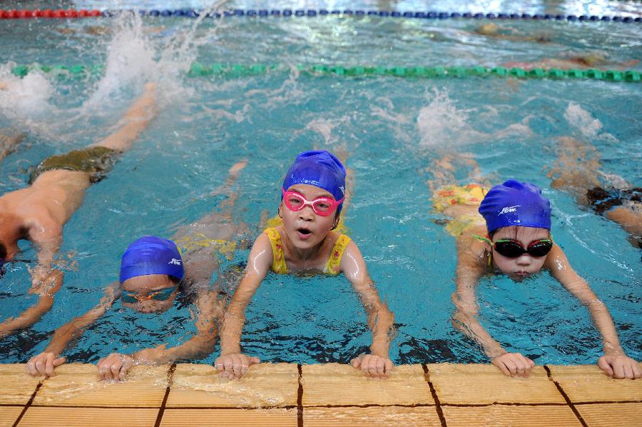 Children learn swimming at an indoor pool in Hangzhou, capital of east China's Zhejiang Province, July 31, 2013. Hangzhou has experienced six days of temperature over 40 degrees Celsius since July 24. Indoor activities like ice skating and swimming has been popular among local citizens to relieve the intense heat. (Xinhua/Ju Huanzong)