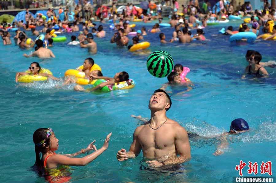 Tourists swarm to the bathing beach in Beijing's Chaoyang Park to escape the stifling heat on July 28, 2013. On the same day, the city's weather authorities issued this summer's second orange high-temperature alert. (Chinanews.com)