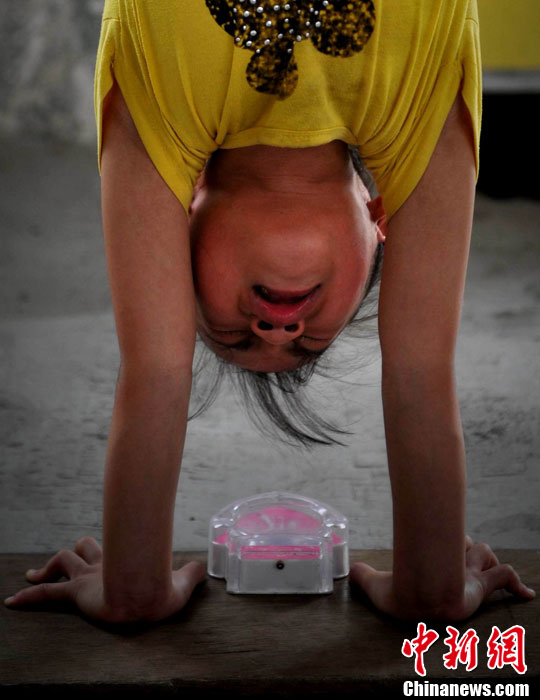 Xiuhua practices handstands. (Chinanews/Wang Dongming)