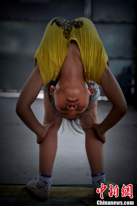 Xiuhua practices in the exercise room. Her body is trained as elastic as a spring. (Chinanews/Wang Dongming)  